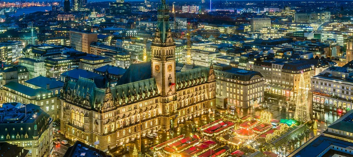 Panoramic aerial view of Hamburg Rathausmarkt Christmas market lit up at night
